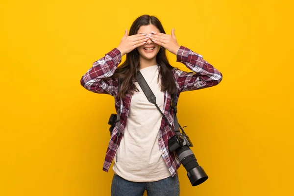 写真家の手で目を覆っている黄色の壁を越えてティーンエイ ジャーの女の子 先にあるものを見てびっくり — ストック写真