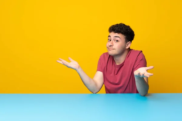 Jovem Com Parede Colorida Mesa Fazendo Gestos Dúvidas — Fotografia de Stock