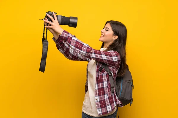 黄色の壁の上のカメラマンのティーンエイ ジャーの女の子 — ストック写真