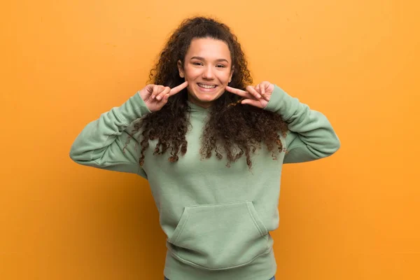 Chica Adolescente Sobre Pared Ocre Sonriendo Con Una Expresión Feliz —  Fotos de Stock