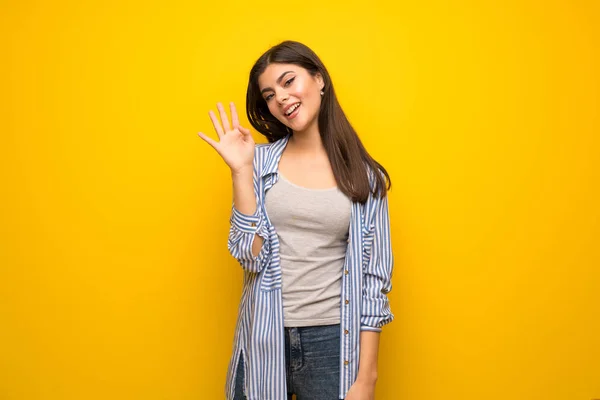 Teenager Mädchen Grüßt Mit Fröhlichem Gesichtsausdruck Über Die Gelbe Wand — Stockfoto