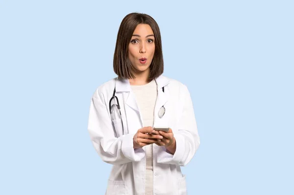 Jovem Médica Surpreendida Enviando Uma Mensagem Sobre Fundo Azul Isolado — Fotografia de Stock