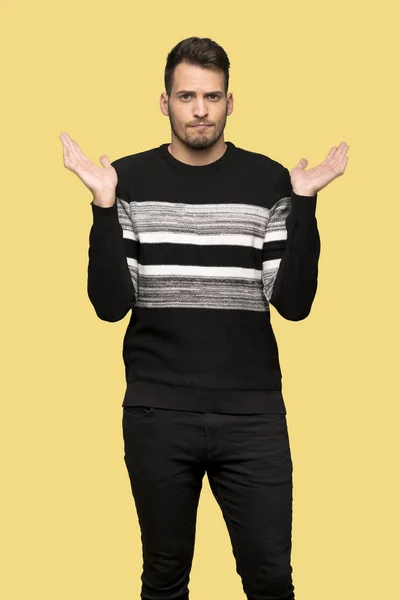 Handsome Man Having Doubts While Raising Hands Yellow Background — Stock Photo, Image