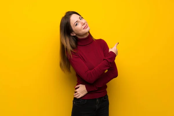 Vrouw Met Coltrui Gele Muur Wijzen Terug — Stockfoto