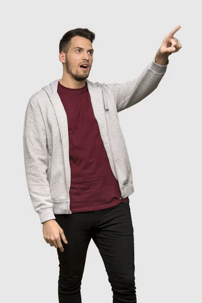 Mann Mit Sweatshirt Zeigt Weg Über Grauen Hintergrund — Stockfoto