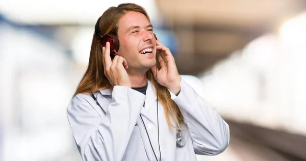 Doctor man listening to music with headphones in a hospital