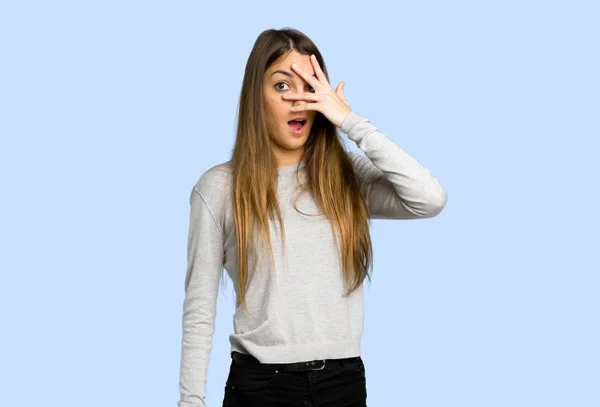 young girl with surprise and shocked facial expression on blue background
