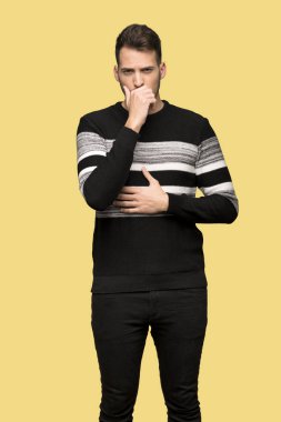 Yakışıklı adam öksürük ile acı ve sarı arka plan üzerinde kötü hissediyor