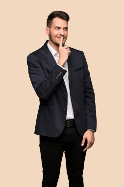 Sessizlik jest belirtisi koyu sarı arka plan üzerinde gösterilen yakışıklı iş adamı