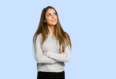 genç kız mavi arka plan üzerinde gülümseyen ararken