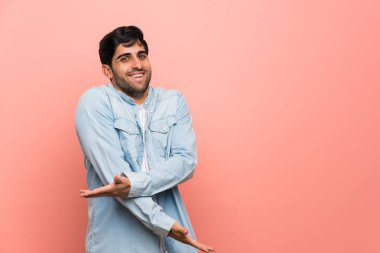 Pembe duvar gülümseyen üzerinde genç adam