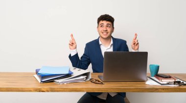 En iyi dilek ve geçiş parmakları olan bir ofiste iş adamı
