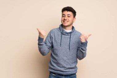 Jest ve gülümseyen Yaşasın ile izole duvarın üzerinden genç adam