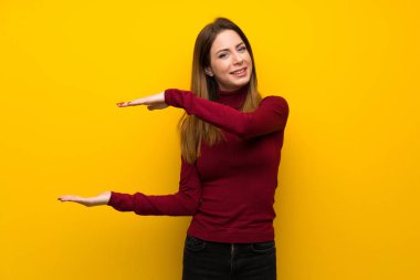 Balıkçı yaka boşaltmak tutan sarı duvarın üzerinden kadınla bir reklam eklemek için