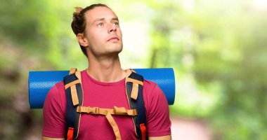 Dağ ciddi yüzle ararken dağ backpacker adamla uzun yürüyüşe çıkan kimse