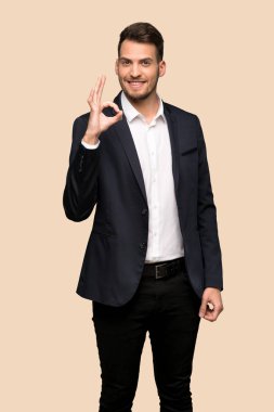 Ok işareti ile parmak koyu sarı arka plan üzerinde gösterilen yakışıklı iş adamı