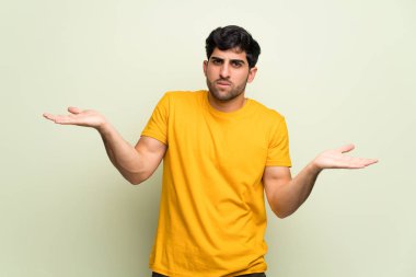 Genç adam mutsuz ve bir şey ile sinirli pembe duvarın üzerinden çünkü bir şey anlamıyor