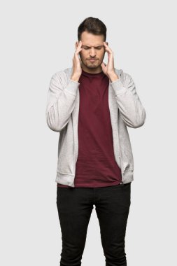 Adam kazak ile gri arka plan üzerinde baş ağrısı ile