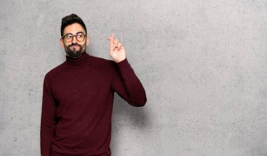 Dokulu duvar'ın üstüne en iyi dilek ve geçiş parmakları olan gözlüklü yakışıklı adam