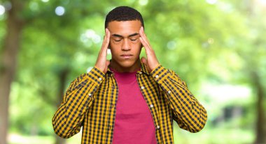 Genç afro Amerikalı adam mutsuz ve bir parkta bir şey ile sinirli