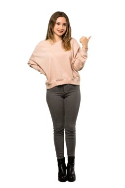 Ürün yalıtılmış beyaz arka plan üzerinde sunmak için genç kız tarafına işaret pembe kazak ile tam uzunlukta bir kadeh