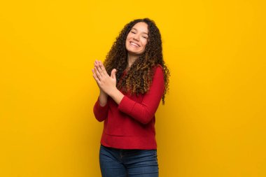 Bir konferansta sunum sonrası sarı duvar alkış üzerinde kırmızı kazaklı genç kızla