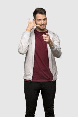 Adam telefonu jest yapma ve açık gri arka plan üzerinde işaret kazak