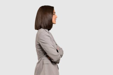 Genç iş kadını lateral pozisyonda izole gri arka plan üzerinde