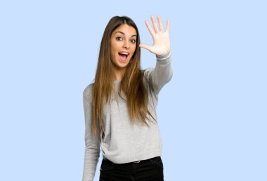 genç kız beş ile mavi arka plan üzerinde parmak sayma