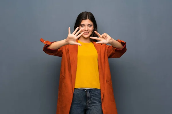 Ragazza Adolescente Con Cappotto Sopra Muro Grigio Contando Otto Con — Foto Stock