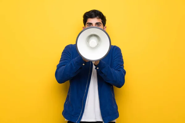 Man Blue Jacket Yellow Wall Shouting Megaphone — Stock Photo, Image