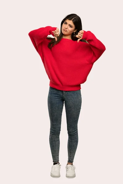 스웨터 아래로 엄지를 보여주는 여자의 — 스톡 사진