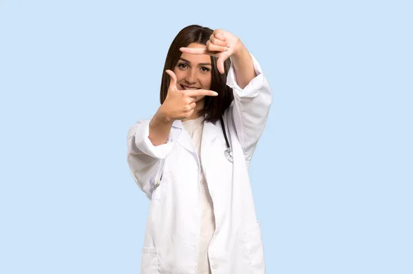 Ung Läkare Kvinna Fokuserar Ansikte Inramning Symbolen Isolerade Blå Bakgrund — Stockfoto