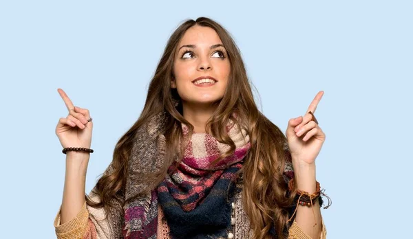 年轻的嬉皮士妇女用食指指向一个伟大的想法在被隔绝的蓝色背景 — 图库照片