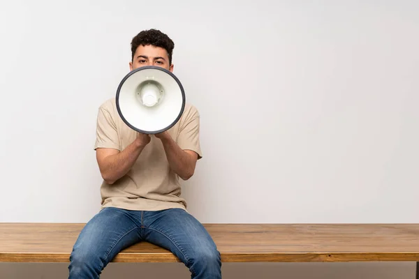 Jongeman Zit Tafel Schreeuwen Door Een Megafoon — Stockfoto