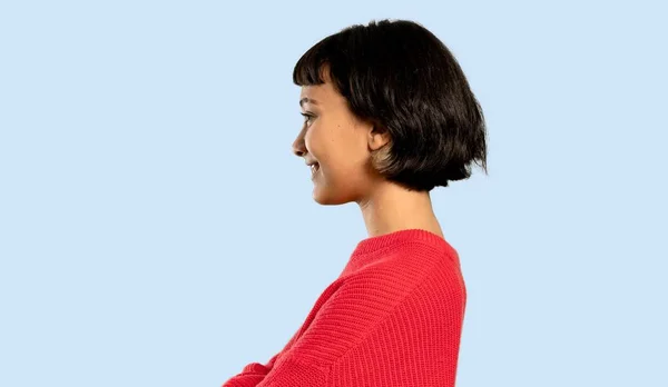 Menina Cabelo Curto Com Suéter Vermelho Posição Lateral Fundo Azul — Fotografia de Stock