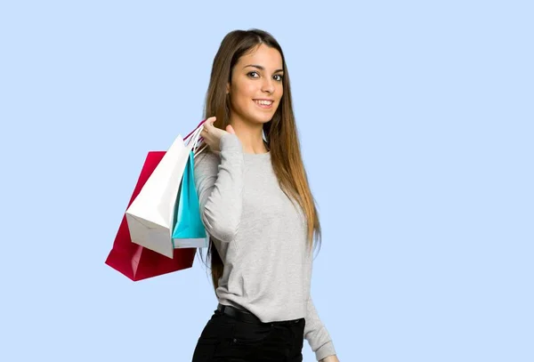 Jovem Segurando Monte Sacos Compras Fundo Azul — Fotografia de Stock