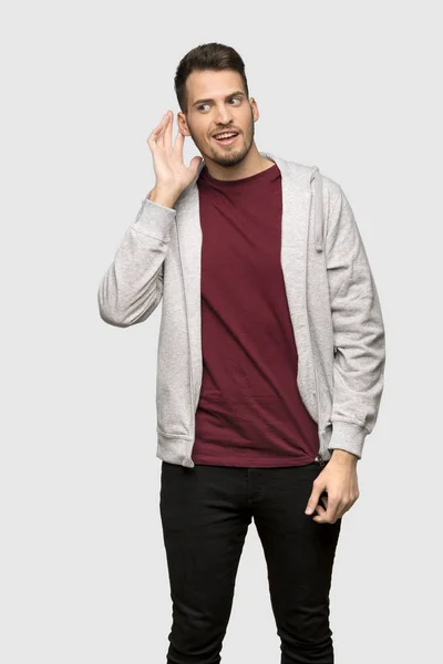Man Met Sweatshirt Luisteren Naar Iets Door Hand Het Oor — Stockfoto