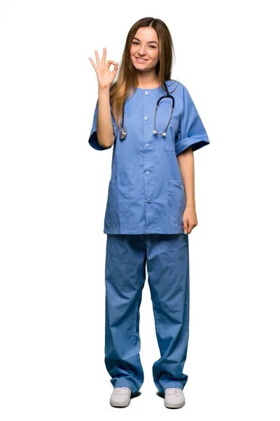 孤立した背景に指で のサインを示す全身若い看護師 — ストック写真