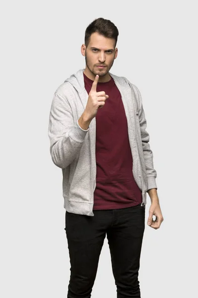 イライラし 灰色の背景の上前方を向くのスエット シャツを持つ男 — ストック写真
