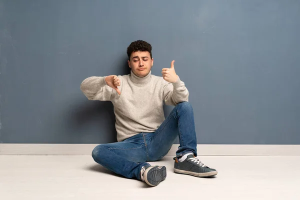 Mladý Muž Sedí Podlaze Takže Dobré Špatné Znamení Rozhodnutý Mezi — Stock fotografie