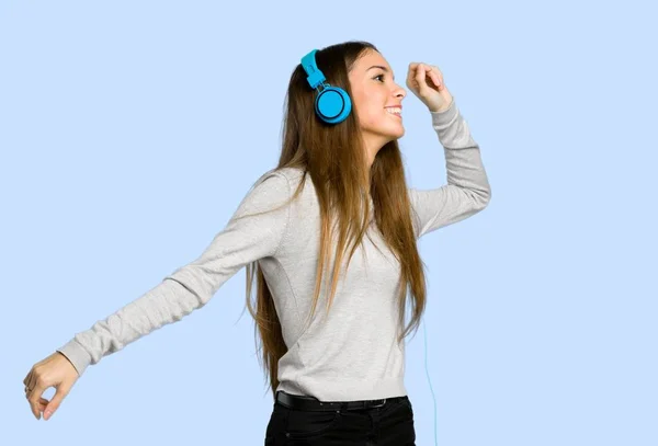 Jovem Ouvindo Música Com Fones Ouvido Dançando Fundo Azul — Fotografia de Stock