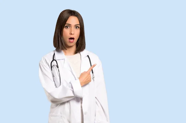 Mladý Lékař Žena Překvapil Ukázal Boční Izolované Modré Pozadí — Stock fotografie