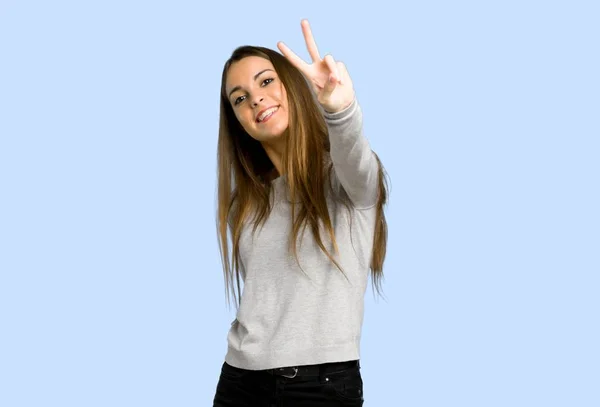 Menina Sorrindo Mostrando Sinal Vitória Fundo Azul — Fotografia de Stock