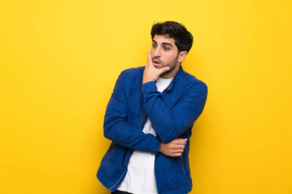 Mann Mit Blauer Jacke Über Gelber Wand Überrascht Und Schockiert — Stockfoto