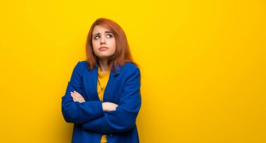 Omuz kaldırma sırasında genç Kızıl saçlı kadın trençkot yapımı ile jest şüpheler