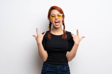 Beyaz duvar rock jest yapma genç Kızıl saçlı kadın