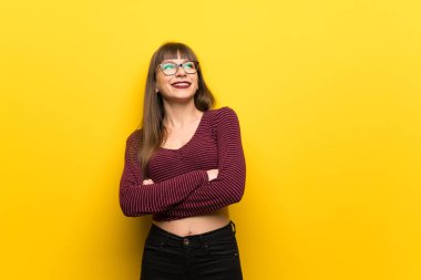 Kadın gözlük gülümseyen süre ararken sarı duvarın üzerinden