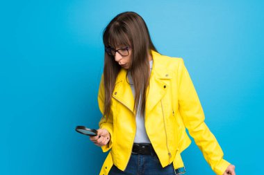 Büyüteç Camı tutan mavi zemin üzerine sarı ceket Bayan