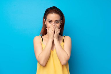 Mavi arka plan çok gülümseyen genç Kızıl saçlı kadın